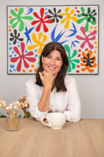 Wide Asleep: Allie Lewis seated in front of bright flowers picture